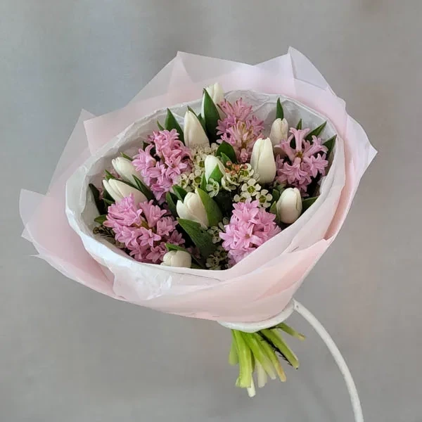 Hyocinths and tulips are used in the bouquet.