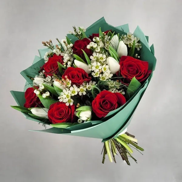 Delicate bouquet with red roses and tulips