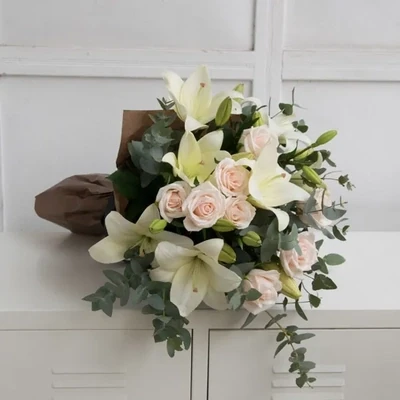 The bouquet is made of lilies and roses in white tones.