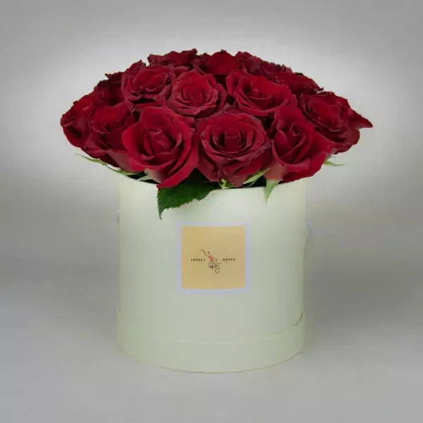 Композиция в круглой коробке состоит из 25 красных роз.
