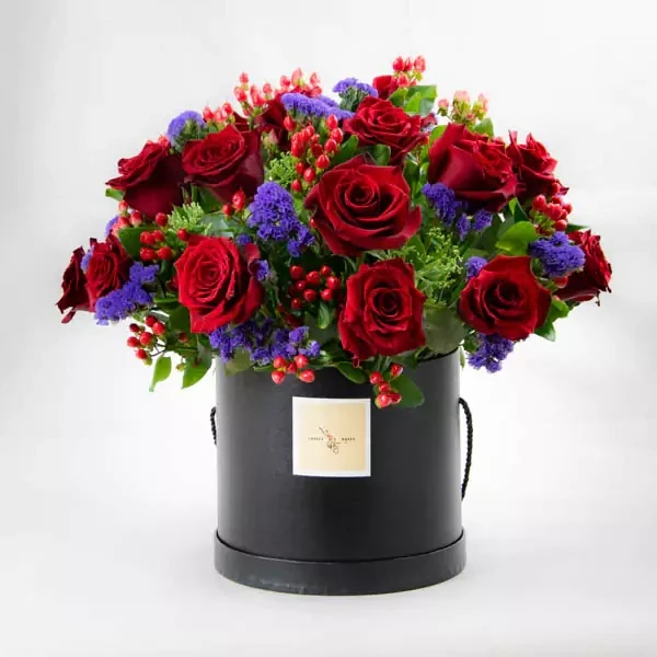 Composition with roses, hypericums, and statice