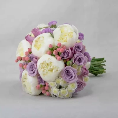 Свадебный букет состоит из роз, пионов и зверобоя.