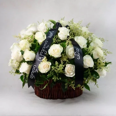 50 white roses in a basket with mourning ribbon