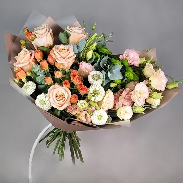 Pink single head roses, orange spray roses and eustomas.