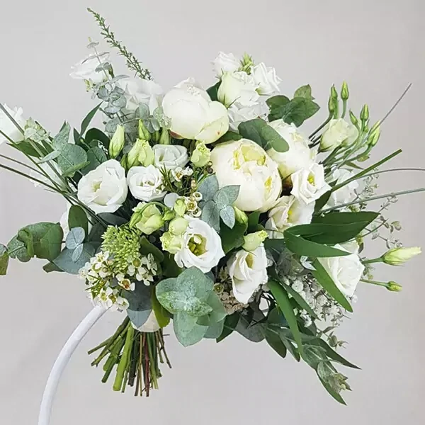 Свадебный букет составлен из белых роз, нежных эустом, пионов и хамелеонов