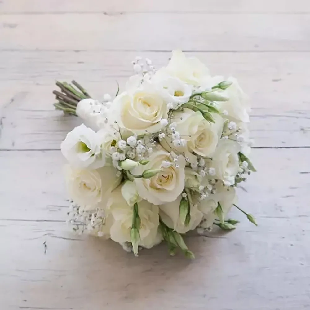 The wedding bouquet is made of white roses and white eustoma
