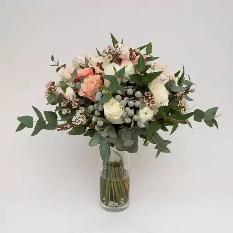 The wedding bouquet is made of green material, with roses in white and peach colors