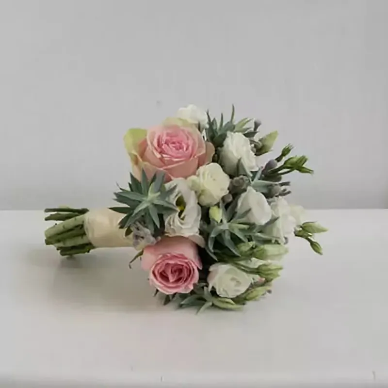 Wedding bouquet with roses and other flowers in purple and pink tones