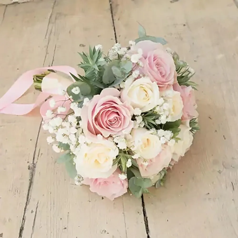 There are white and pink roses in the wedding bouquet