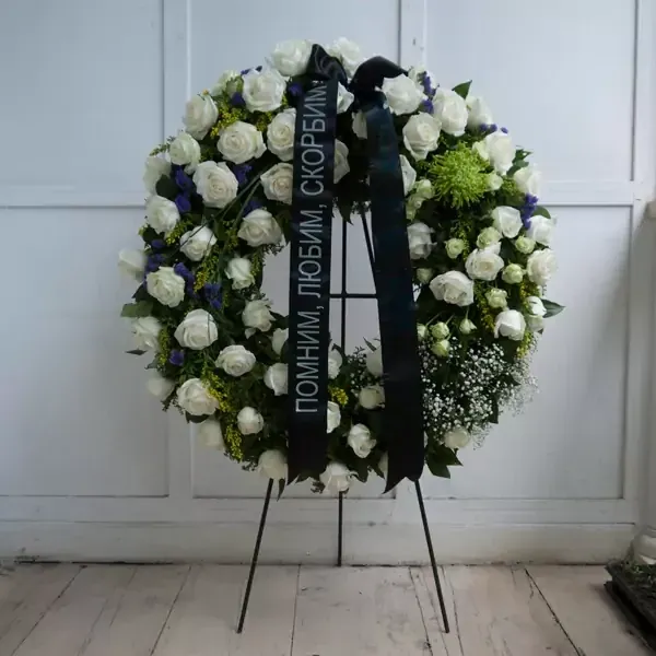 A large funeral wreath in white with frame support. The average diameter of this wreath is 65 centi…