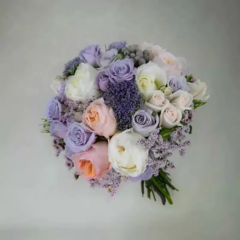 The wedding bouquet is made in purple tones with roses, trachelium and other flowers