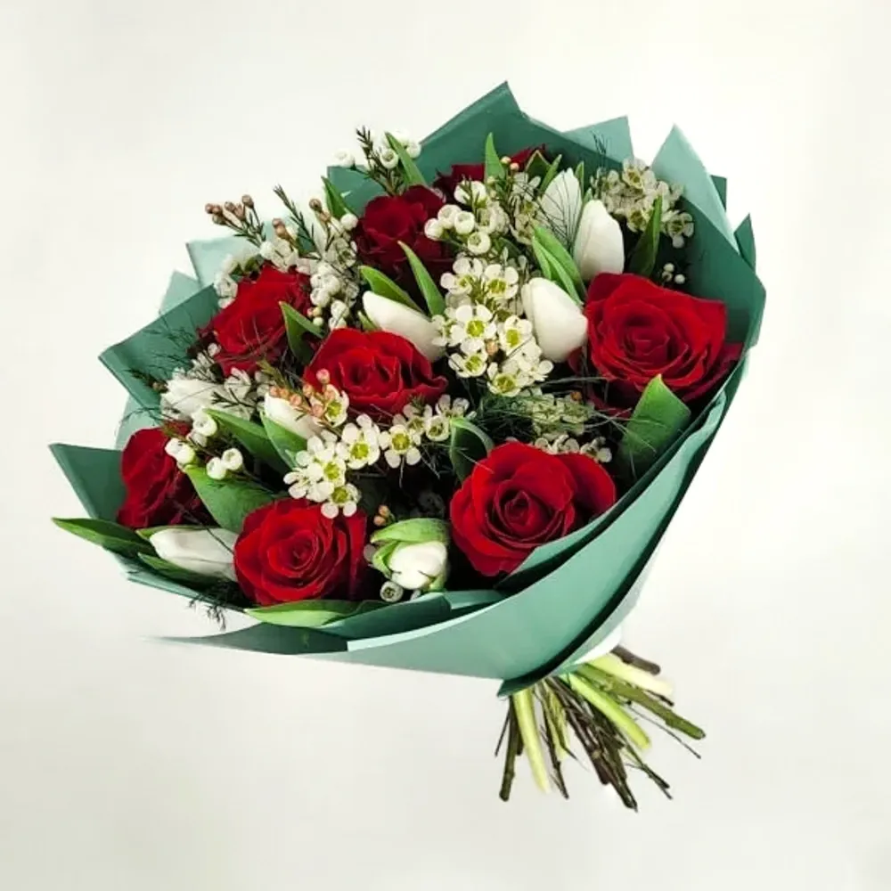 Delicate bouquet with red roses and tulips