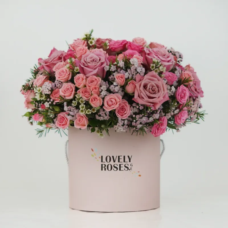 Pink roses with hypericum in a box