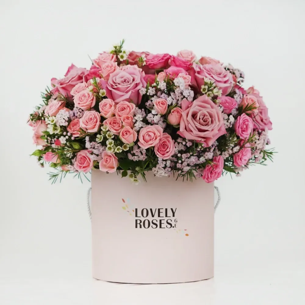 Pink roses with hypericum in a box