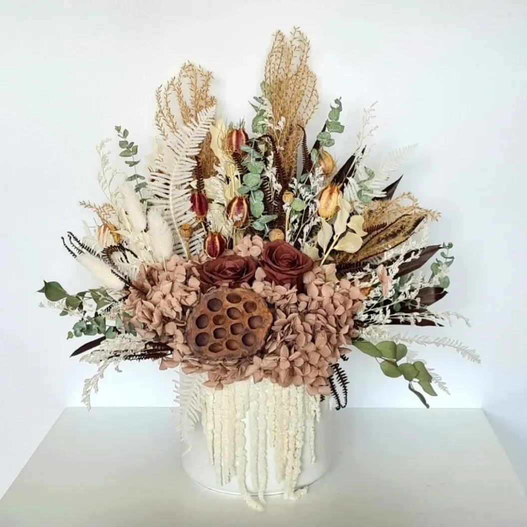 Elegant dried floral arrangement in white ceramic pot, perfect for adding timeless beauty to a home or office.