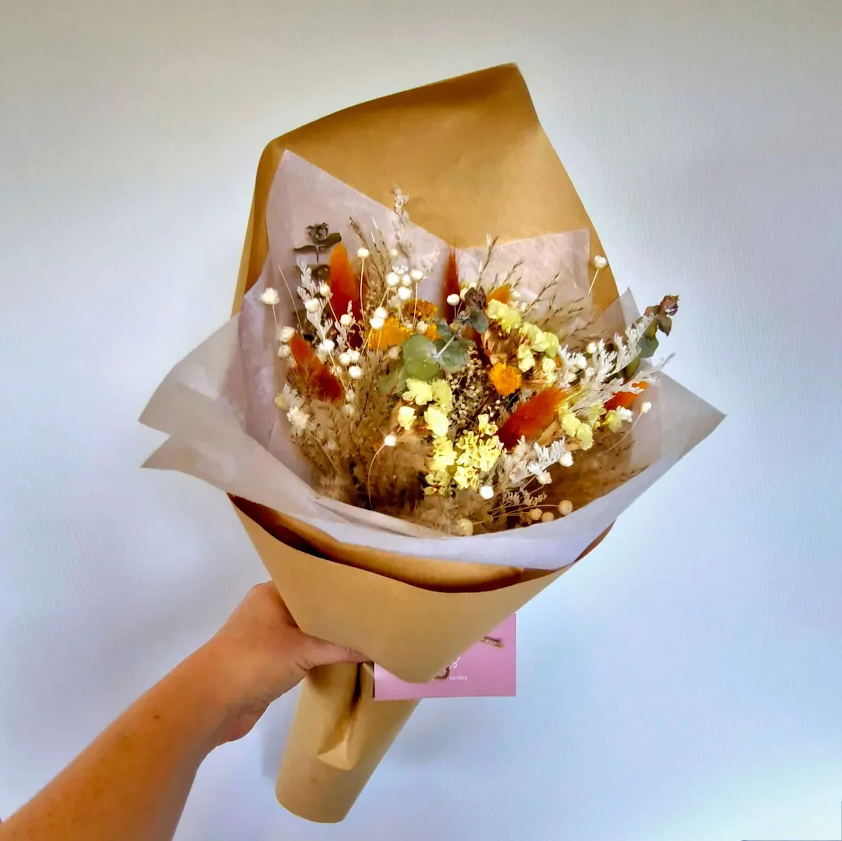 Harmony dried bouquet in warm orange and yellow tones with preserved florals and soft natural textures.