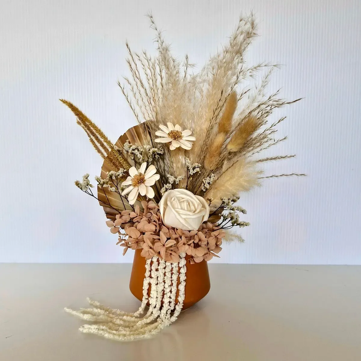 April dried floral arrangement in terracotta pot with preserved hydrangea, sola rose, marget flowers, and ornamental grasses.