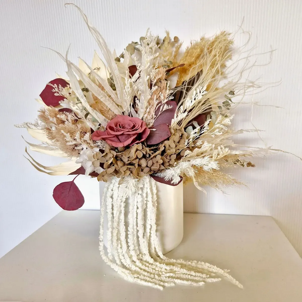 Right side view of Beloved dried flower arrangement in white ceramic pot with hydrangea, rose, amaranthus, and ferns.
