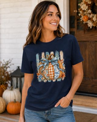 Woman wearing a navy pumpkin graphic T-shirt with blue bow and mixed floral, gingham, leopard, and toile patterns.