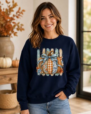 Model wearing a navy fall pumpkin sweatshirt featuring a blue bow, gingham, floral, leopard and toile prints.
