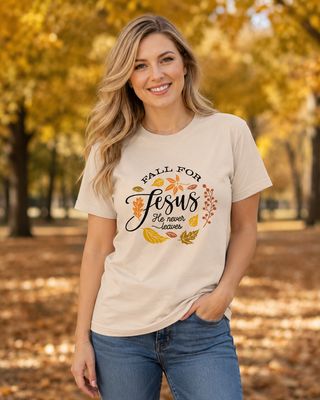 Blonde woman wearing a cream “Fall for Jesus” Christian T-shirt in a golden autumn park.