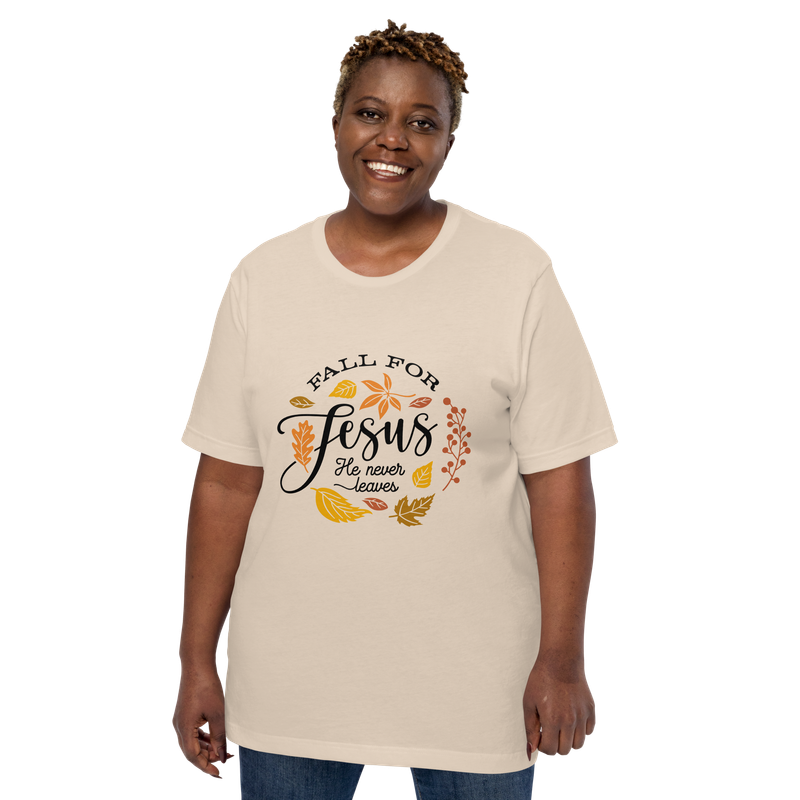 Smiling woman wearing a soft cream “Fall for Jesus, He Never Leaves” Christian fall T-shirt.
