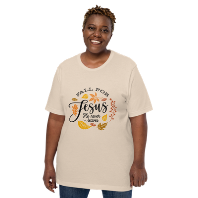 Smiling woman wearing a soft cream “Fall for Jesus, He Never Leaves” Christian fall T-shirt.