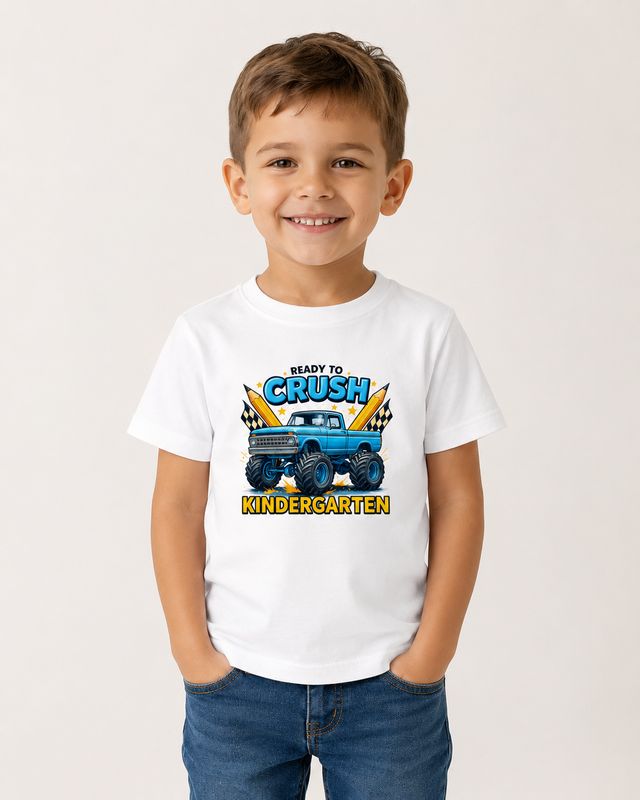 Smiling boy wearing a white “Ready to Crush Kindergarten” monster truck T-shirt for back-to-school.