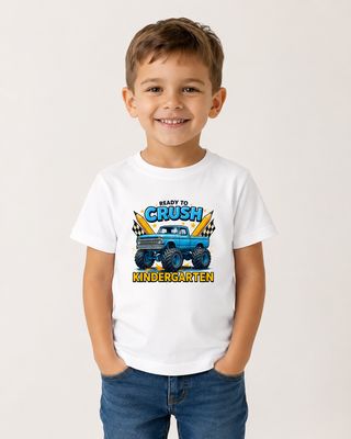 Smiling boy wearing a white “Ready to Crush Kindergarten” monster truck T-shirt for back-to-school.