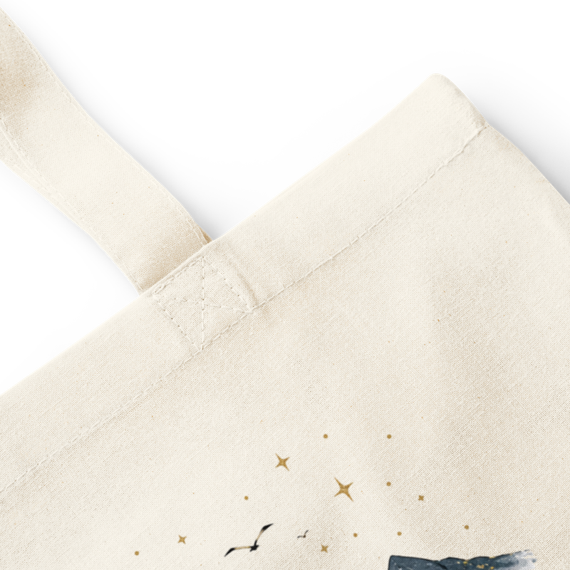 Close-up of natural cotton tote bag stitching, handle, canvas texture, and watercolor faith mountain print.