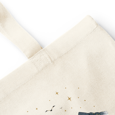 Close-up of natural cotton tote bag stitching, handle, canvas texture, and watercolor faith mountain print.