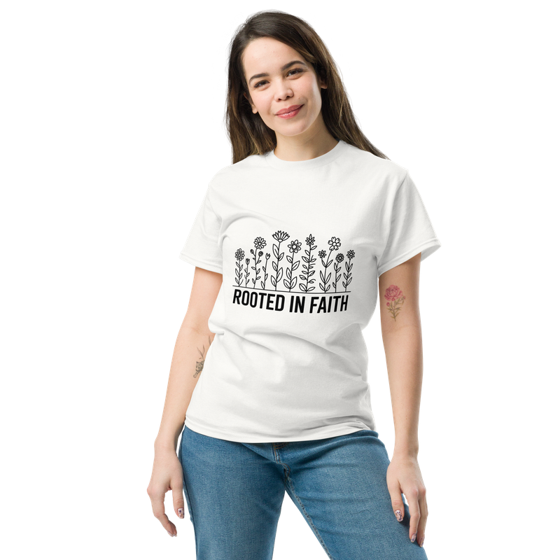 Woman wearing a white Rooted in Faith Christian T-shirt with black wildflower design and blue jeans.
