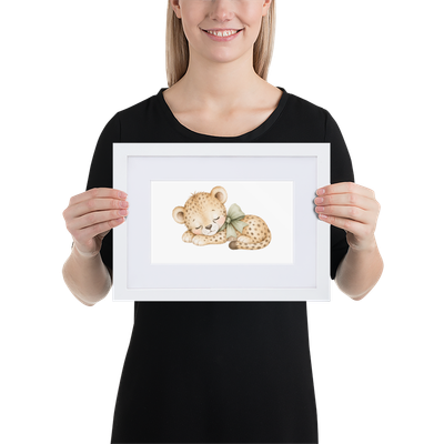 21 × 30 cm: White framed nursery print featuring a sleeping baby cheetah with a sage green bow, held by a woman.
