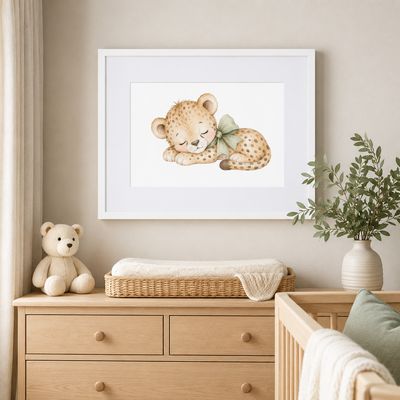 White framed sleeping baby cheetah nursery print displayed above a natural wood changing table in a neutral nursery.