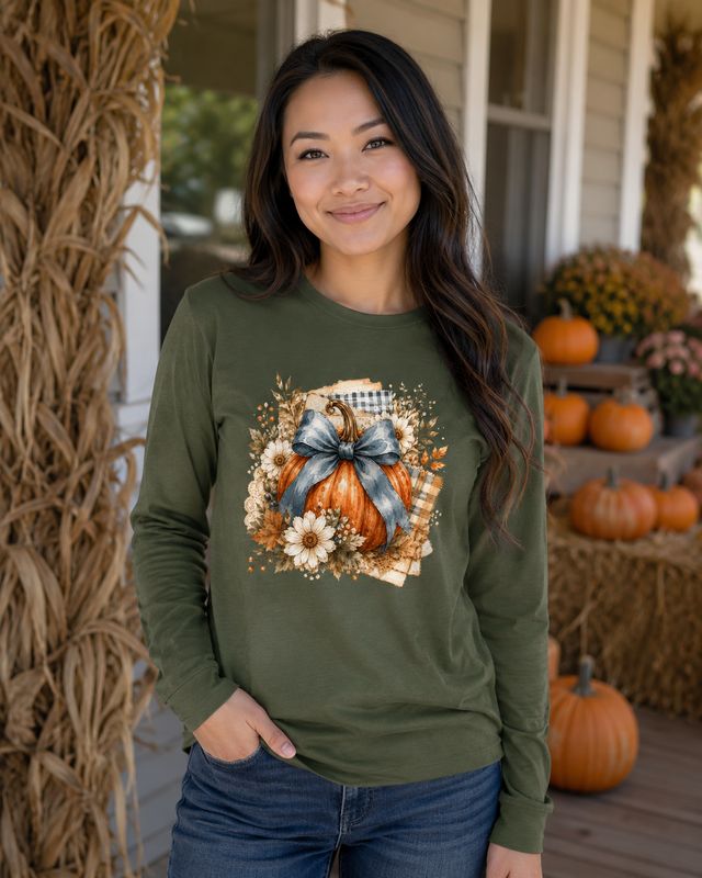 Asian woman wearing a military green pumpkin bow long sleeve shirt on a rustic fall porch.