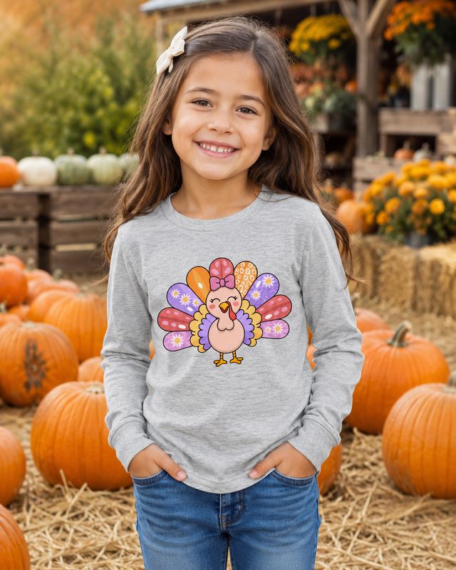 Girl wearing an athletic heather kids long sleeve turkey shirt at a festive pumpkin patch.