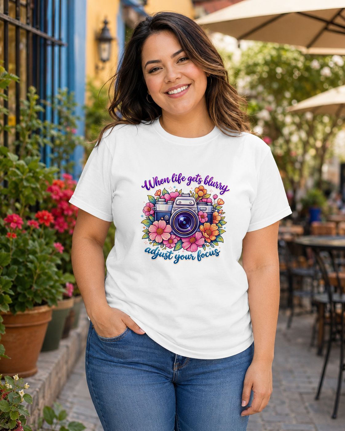 Curvy Latina woman wearing a white floral camera T-shirt with the inspirational “Adjust your focus” photography quote.
