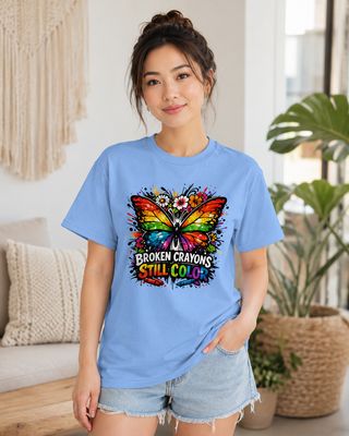 Petite Asian woman modeling a Carolina blue Broken Crayons Still Color butterfly graphic T-shirt and denim shorts.