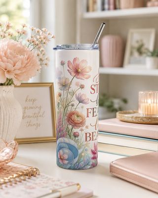 20 oz floral stainless steel tumbler showing the fourth side beside books, flowers, and pastel desk decor.