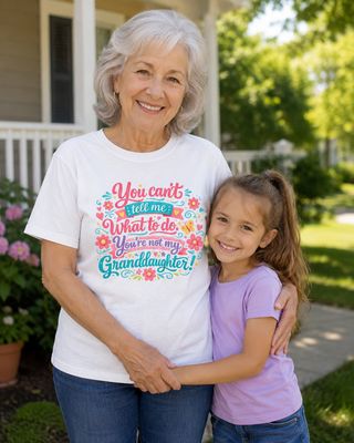 Smiling grandmother wearing a white granddaughter quote T-shirt while posing with her young granddaughter.