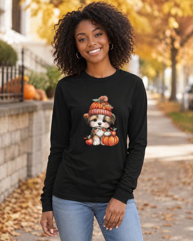 Black long sleeve fall shirt with cute puppy and pumpkin graphic modeled by a smiling woman outdoors.