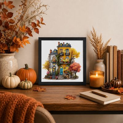 Black framed autumn townhouse wall art styled on a desk with pumpkins, fall leaves, candle, and cozy seasonal decor.