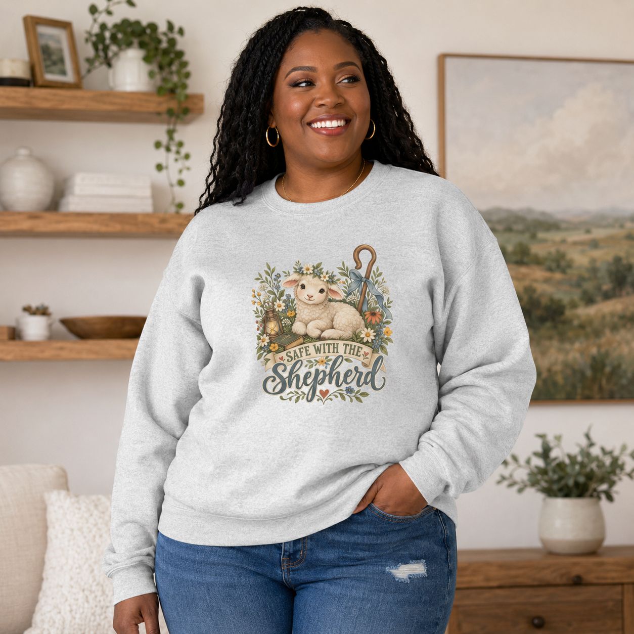 Ash: Plus-size Black woman wearing ash Christian sweatshirt with lamb and “Safe With the Shepherd” graphic in cozy room.