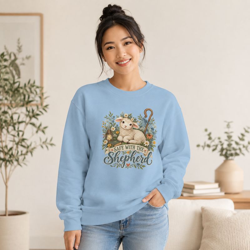 Light Blue: Asian woman wearing light blue Christian sweatshirt with lamb floral “Safe With the Shepherd” design indoors.