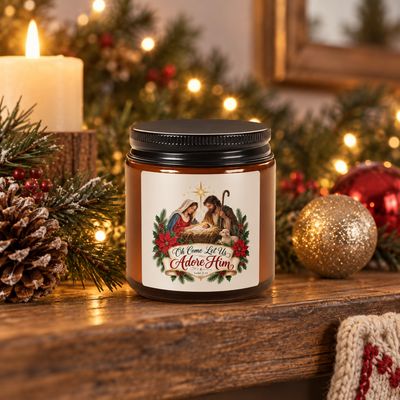 Christian Nativity Christmas soy candle in amber glass displayed on a festive mantel with evergreen, ornaments, pinecones, an