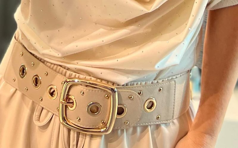 Beige riem op een rekker afgewerkt met goud