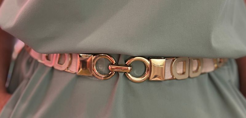 Beige riem met goud op een rekker