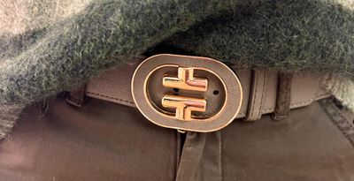 Kaki riem afgewerkt met goud op een rekker