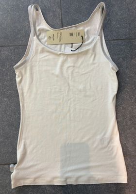 Witte top in travelstof met glitter afgewerkt op de schouder