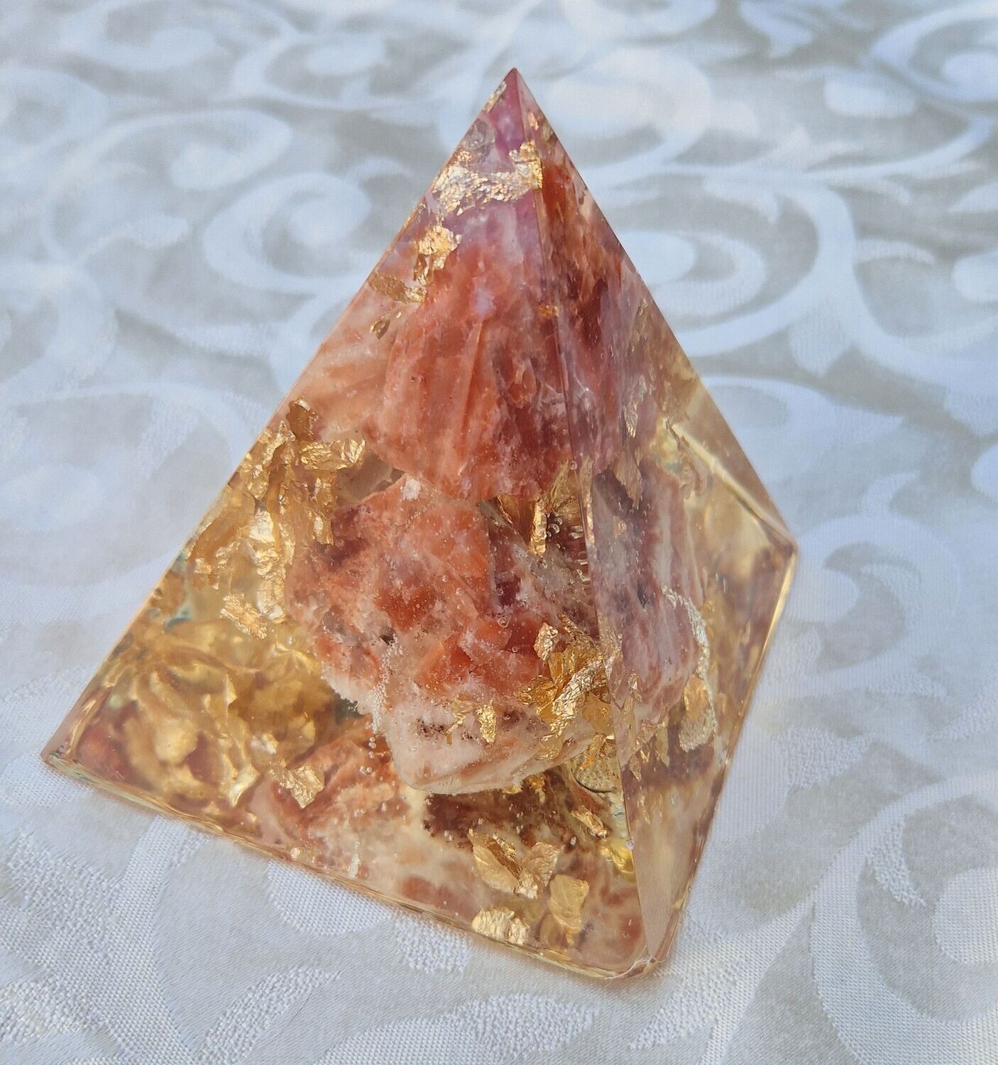 ​Orgonit Pyramide - mit roten Calcit Rohsteinen mit goldfarbenem Schlagmetall